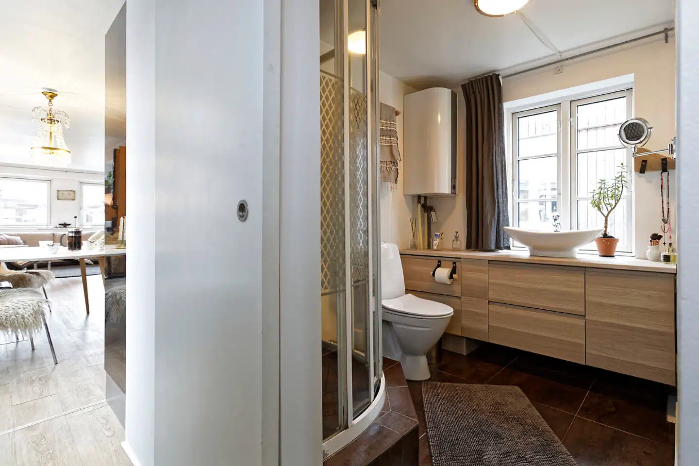 Centralt på båden findes badeværelset med tapetvæg med palmebladsmotiv fra Tapetforum. Alt ser normalt ud, men når der trækkes ud i toilettet, høres den rumlede lyd fra rør og pumpe.