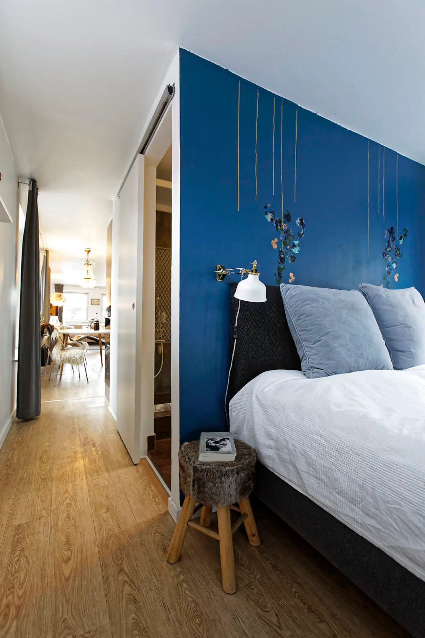 Fra entreen træder man som det første ind i soveværelset. Væggen er malet med Dyrups ”Dark energi”, og en veninde har udsmykket væggen bagefter.