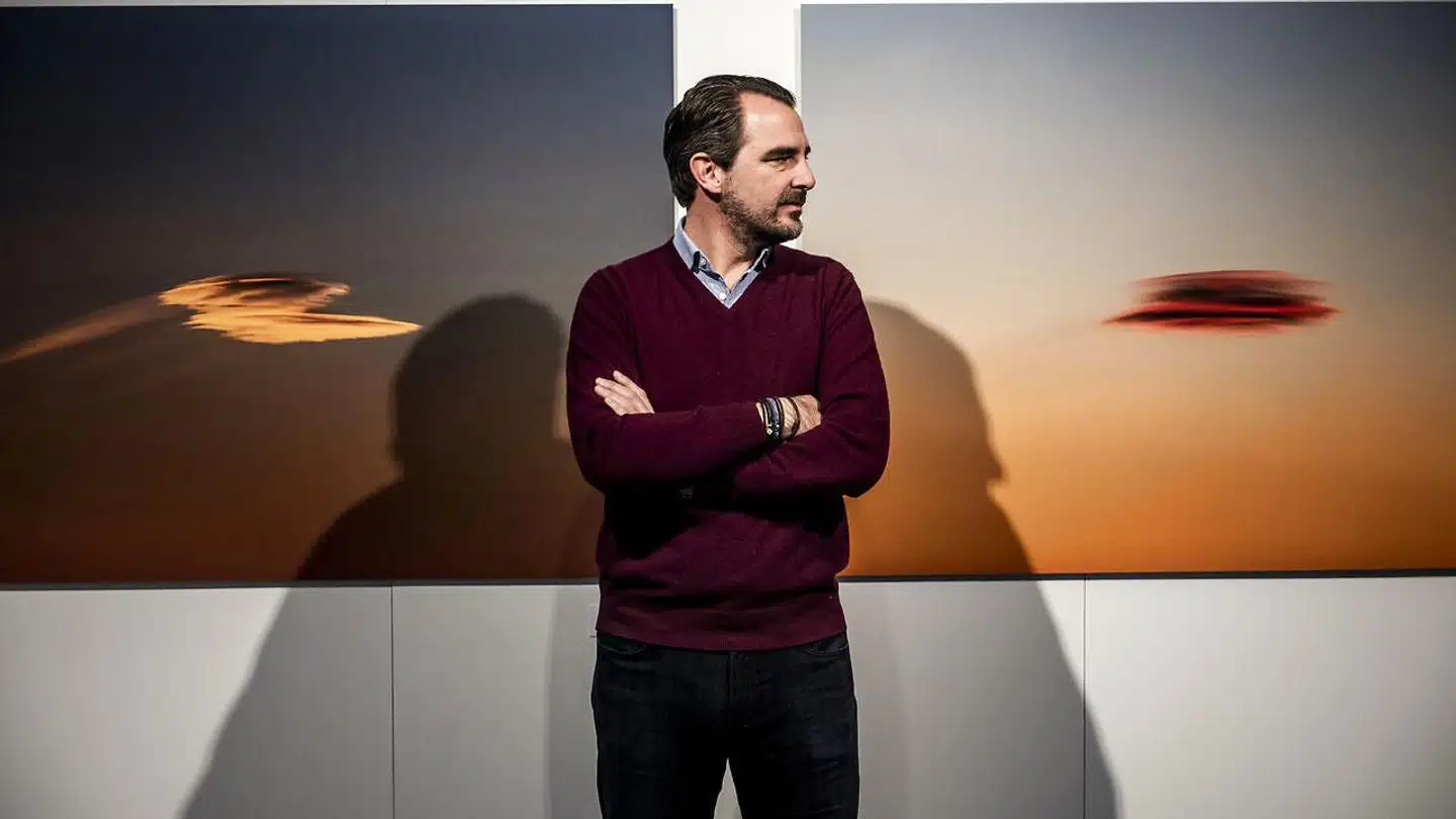 Prins Nikolaos mellem to billeder med titlerne »Arrival« og »Celestial Brushstroke II«, som er taget med bare 90 sekunders mellemrum. Titlen »Arrival« hentyder i øvrigt til de to skyers form på billedet til venstre - som to flyvende tallerkener på vej mod Jorden.