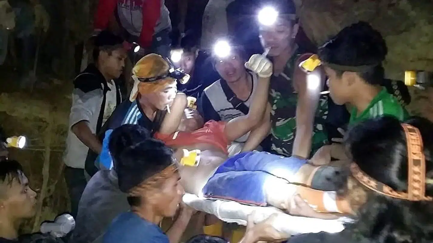 Redningbsarbejdere bærer en overlevende ud fra den illegale og sammenstyrtede guldmine på den indonesiske ø Sulawesi.