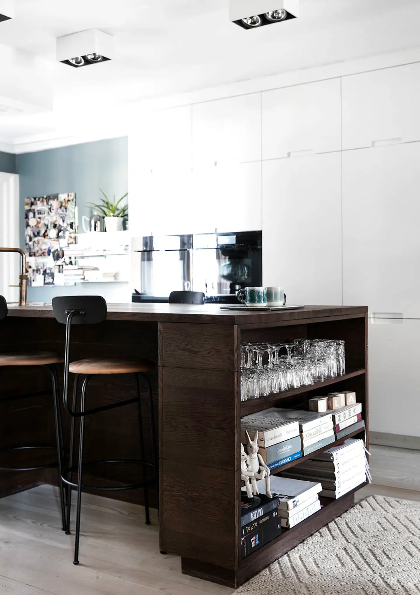 Køkkenøen er åben i enderne, hvor der er indbygget en reol til parrets lækre kogebøger. Kopperne er fra Studio Arhoj.