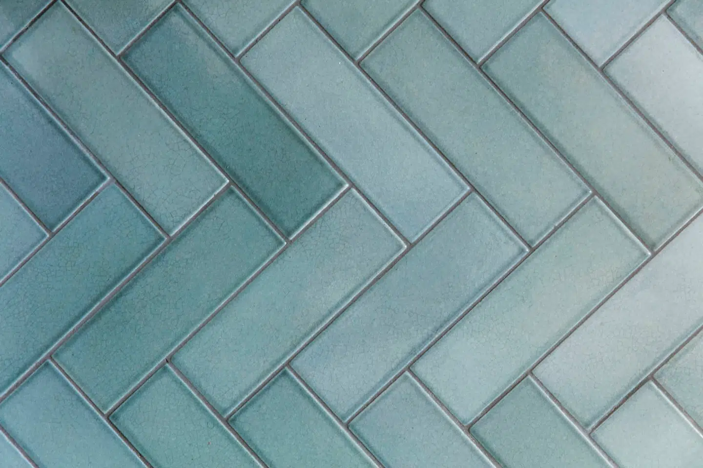 Badeværelset har fået et luksuspræg med bl.a. gulv af håndgjorte lavastensfliser fra Made A Mano, som er lagt i sildebensmønster, som fungerer overraskende godt i det lille rum.