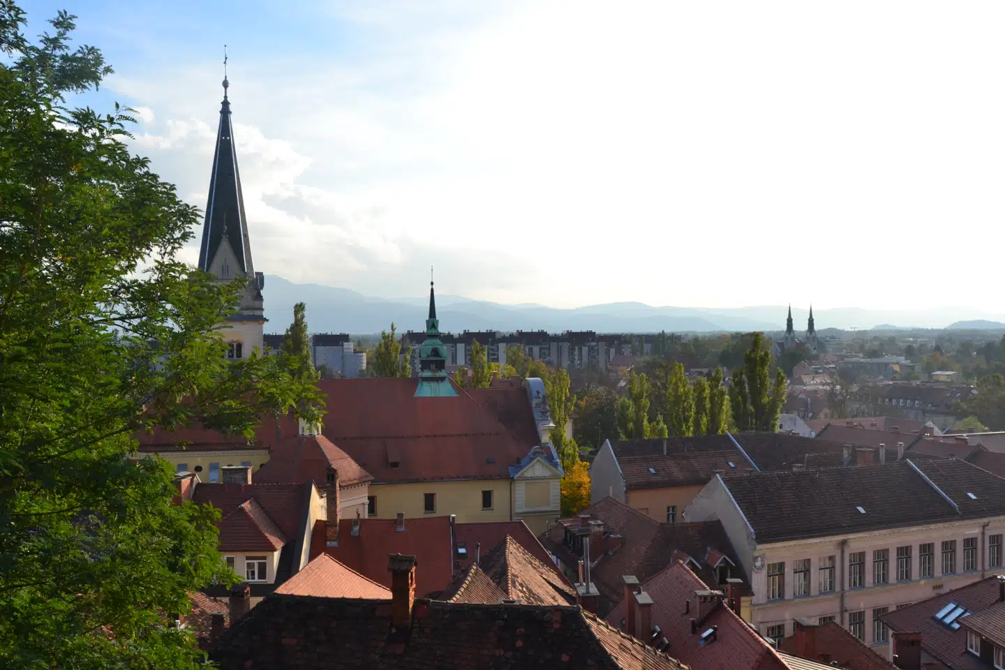 Oppe fra borghøjen er der et raffineret kig til kirkespir, tegltage – og længst ude Sloveniens bjerge.