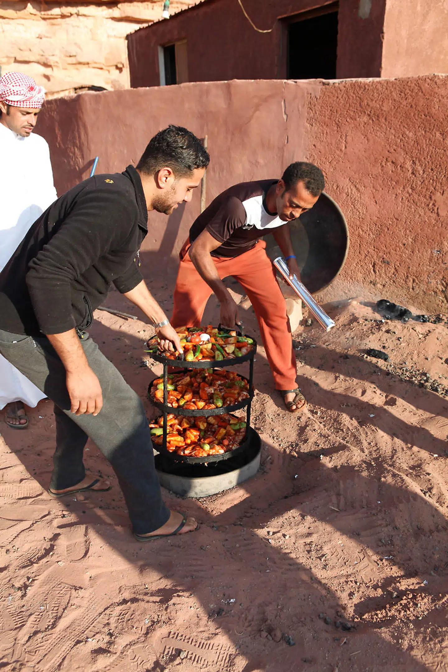 Aftensmaden tilberedes tildækket i et hul i jorden under stærk varme – en traditionel metode, beduinerne har anvendt i århundreder.