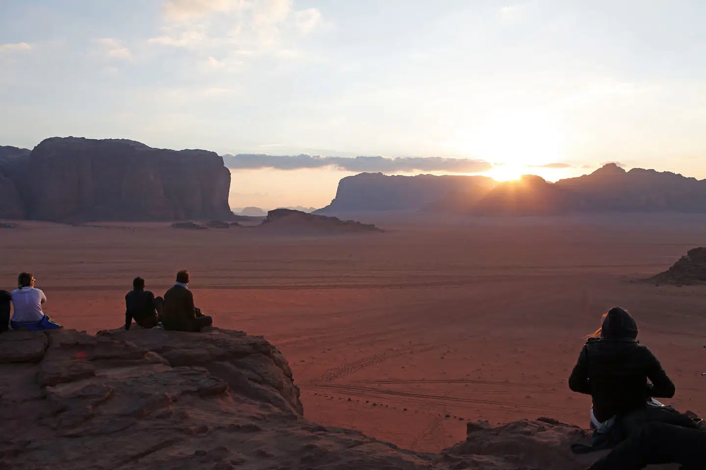På en klippe over Wadi Rum Beduin Camp nydes de sidste af dagens solstråler. Så snart solen er gået ned, falder temperaturen mærkbart, så især i vintertiden er det en god idé med en sweater.