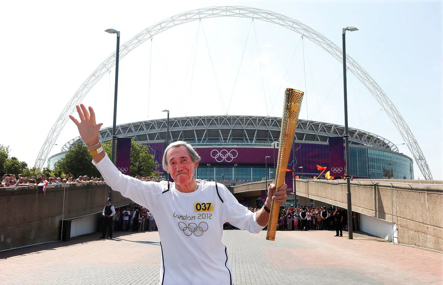 FILE PHOTO: British soccer player Gordon Banks, who was goalkeeper for England in the 1966 World Cup, runs with the London 2012 Olympic torch outside Wembley Stadium in northwest London July 25, 2012. REUTERS/Suzanne Plunkett (BRITAIN - Tags: SPORT OLYMPICS SOCCER)/File Photo