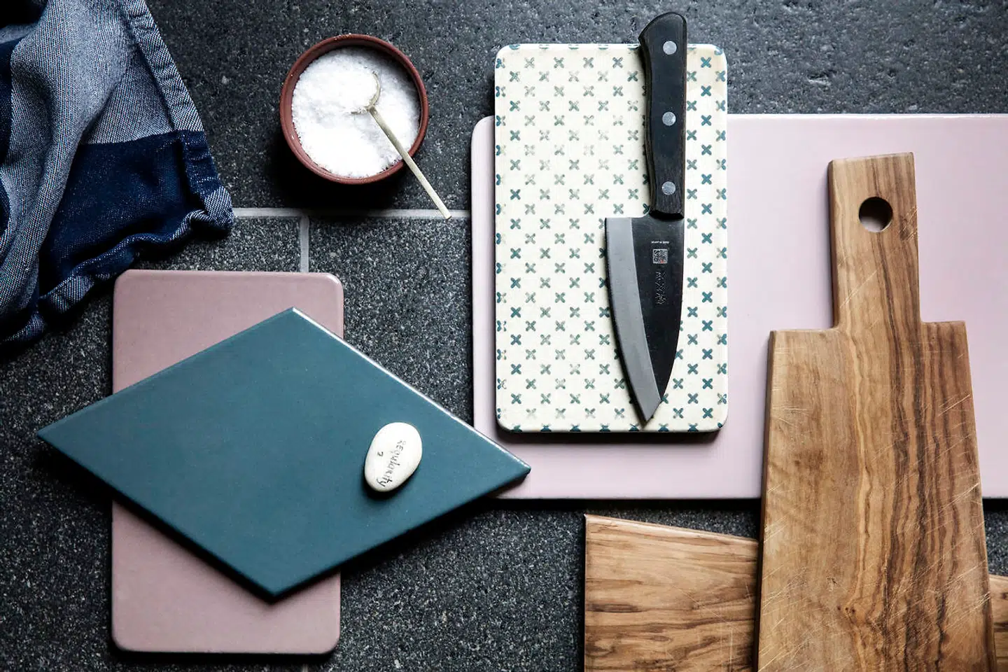 De grå og lyserøde toner går ligesom materialevalg igen i køkkengrejet. Lavasten fra File Under Pop.