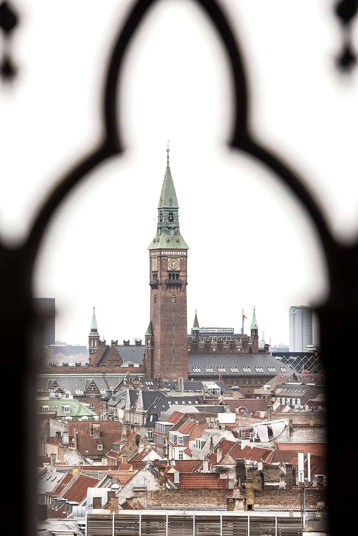 Nikolaj Kirke er den tredje kirke, der blev opført i København. Tidligere var kirkernes tårne og spir de højeste punkter i byen. Men i mere moderne og verdslige tider er det politikkens og forvaltningens bygninger, der rager højest op. Som her Københavns Rådhus set fra toppen af Nikolaj Kirke.