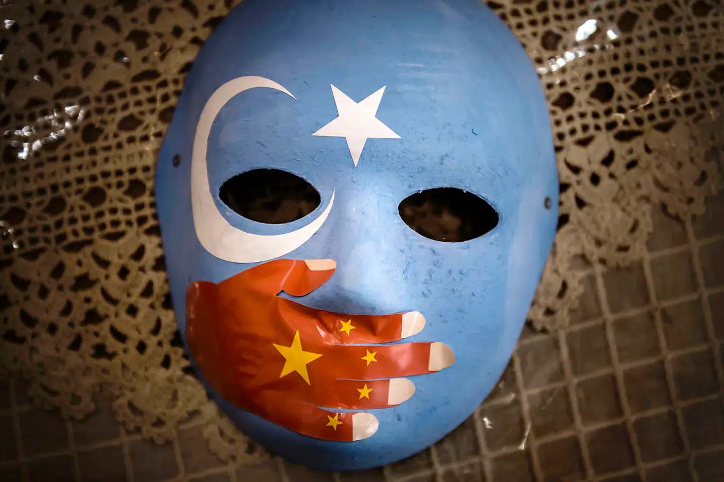 Masken er til salg i en butik i arbejderkvarteret Zeytinburnu i Istanbul. Den bliver brugt til demonstrationer, og den blå farve med den hvide måne og stjerne er flaget for Østturkistan, som uighurerne kalder Xinjiang.