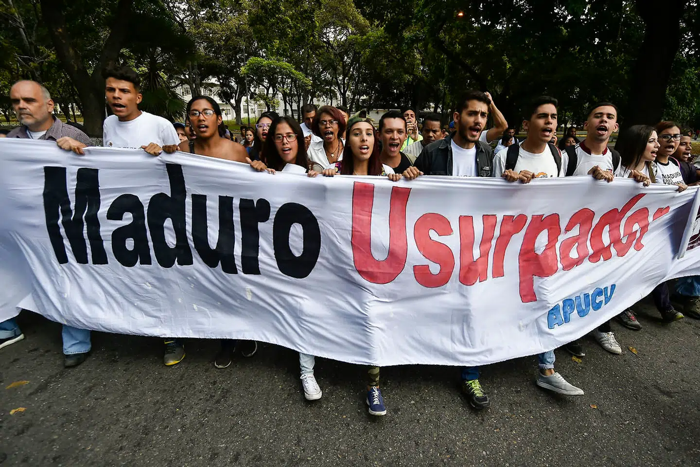 »Maduro tronraneren« står der på banderet som studerende fra Venezuela's Central University (UCV) i Caracas, som de holder foran sig gennem en protest anført af oppositionslederen og selvudråbte »fungerende præsident« i Venezuela Juan Guaido d. 30 januar. (Photo by Luis ROBAYO / AFP)