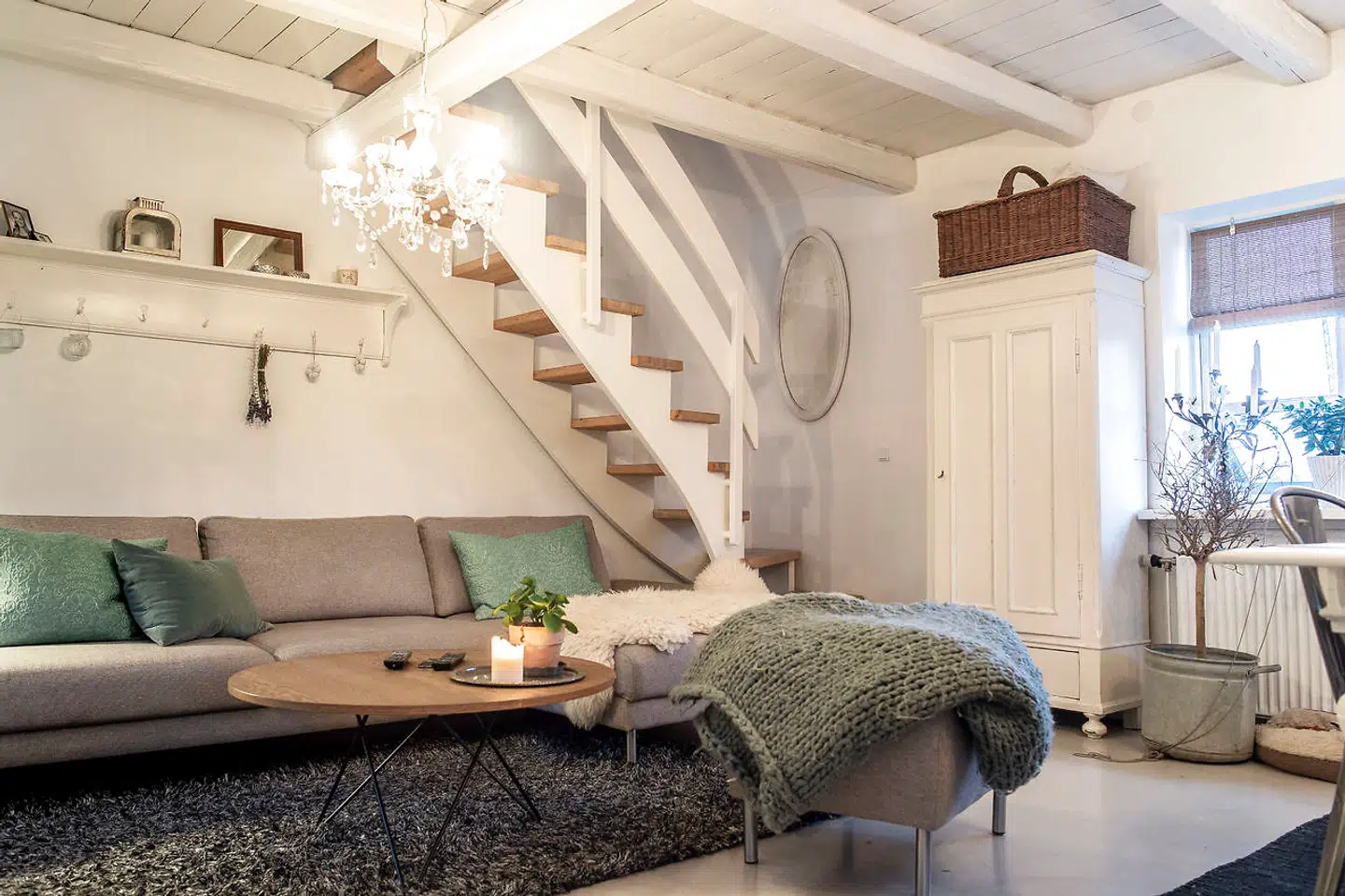 Blå grønne toner er brugt flittigt på tekstilerne i stuens store flydersofa, hvor familien samles om aftenen.