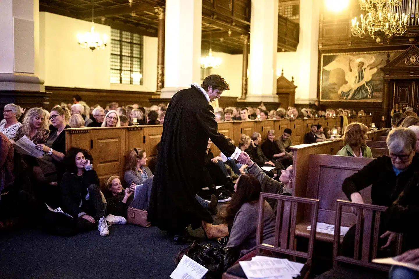 Præst Jens Biegel-Fogh hilser på de fremmødte, der er kommet for at synge Simon & Garfunkel ved fællessangsgudstjenesten i Helligåndskirken i København.
