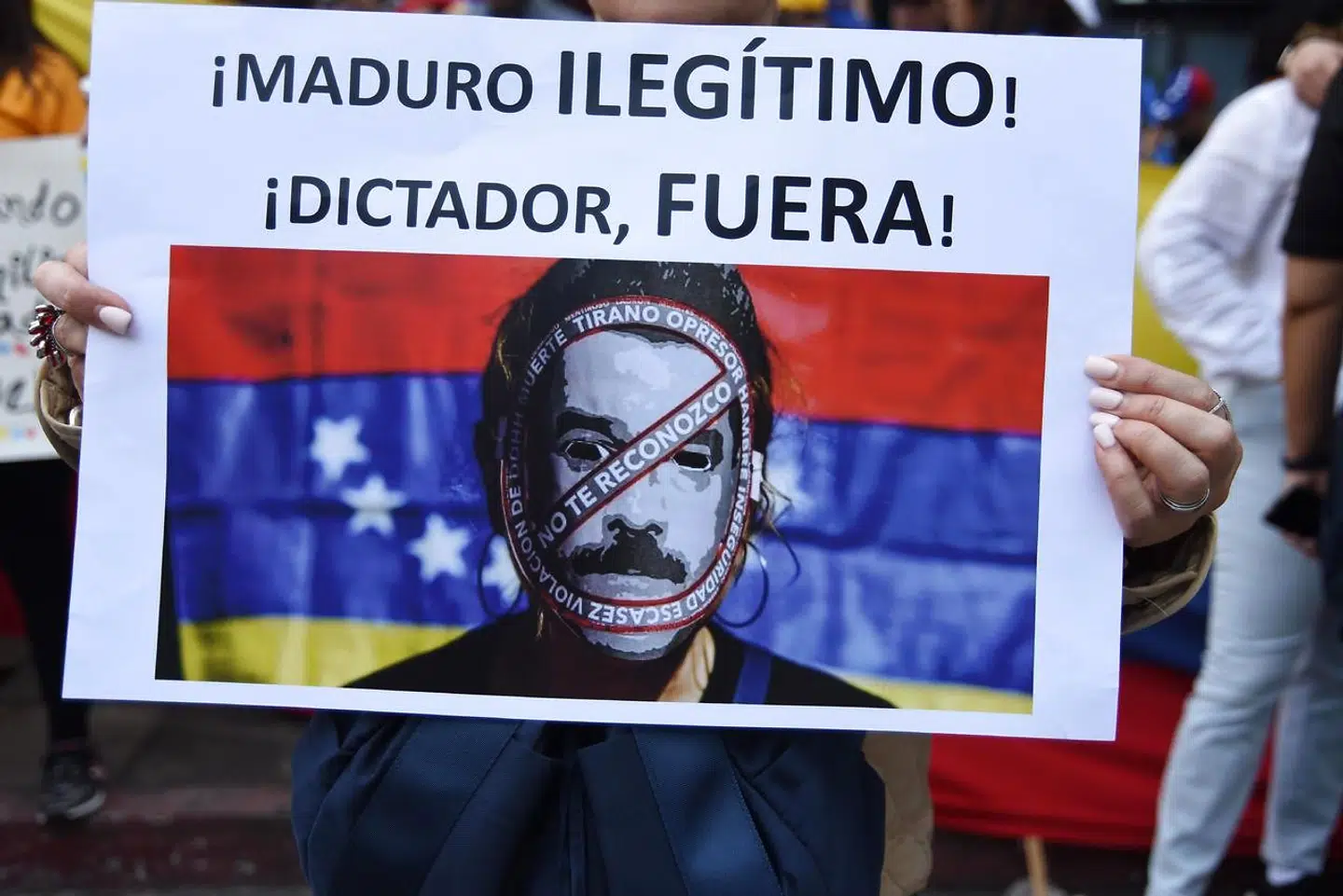 »Maduro er illegitim! Diktator, skrid!« står der på skiltet, som en demonstrant holder op under onsdagens demonstration med klar adresse til den venstrepopulistiske leders demokratiske julelege.