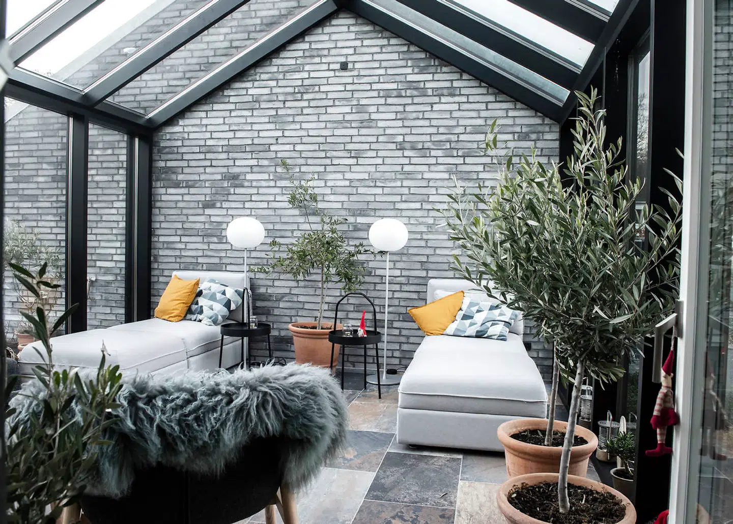 Det isolerede glashus med gulvvarme er en uundværlig favorit i ægteparret Christophersens nybyggede villa. En indretningsarkitekt har foreslået møbelindkøb og placering med uhindret udsyn til havet.