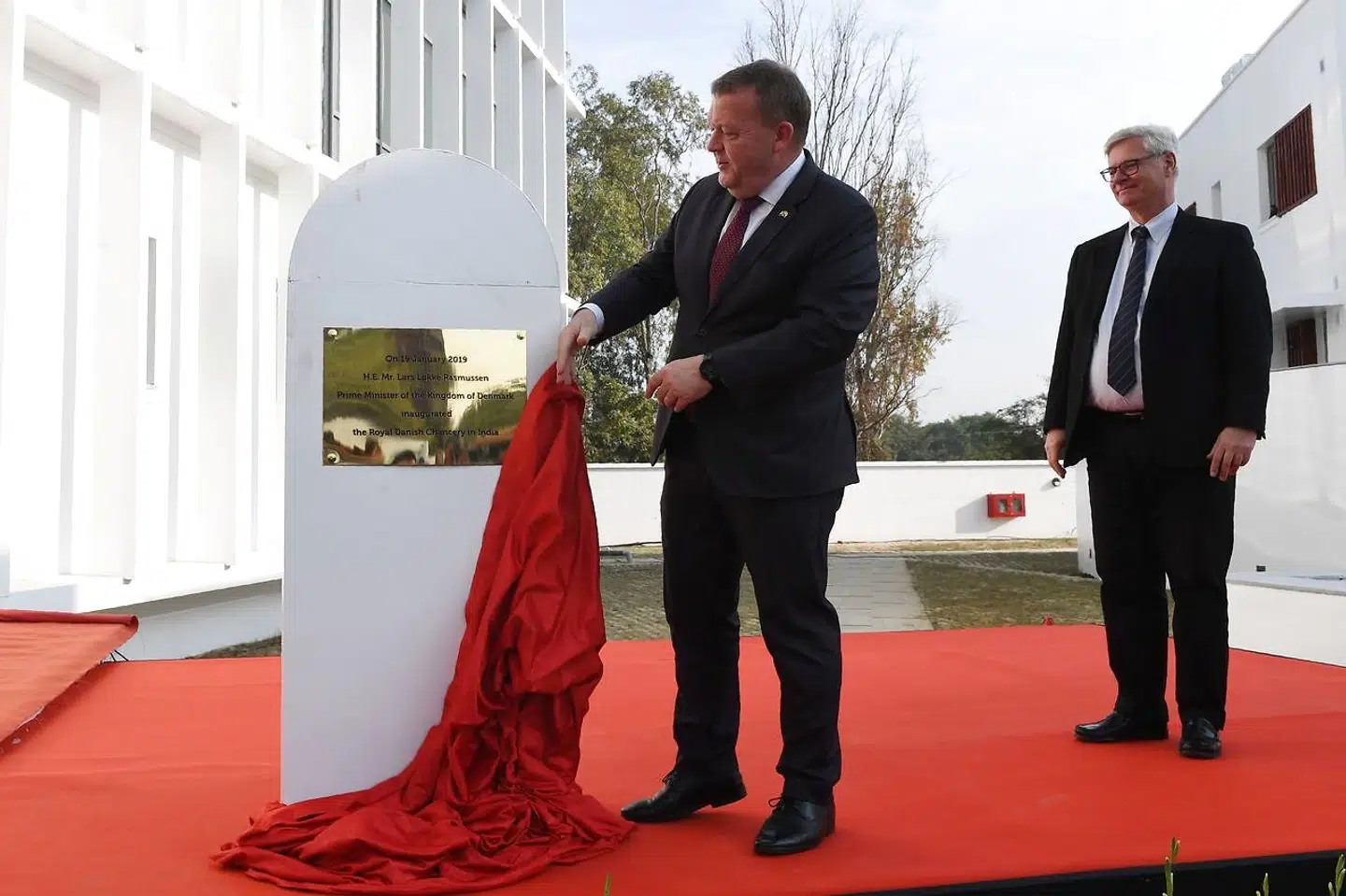 Denmark's Prime Minister Lars Lokke Rasmussen (L) unveils the inauguration plate as Denmark's Ambassador to India Peter Taksoe-Jensen looks on during the opening ceremony of the Danish embassy in New Delhi on January 19, 2019. (Photo by Money SHARMA / AFP)