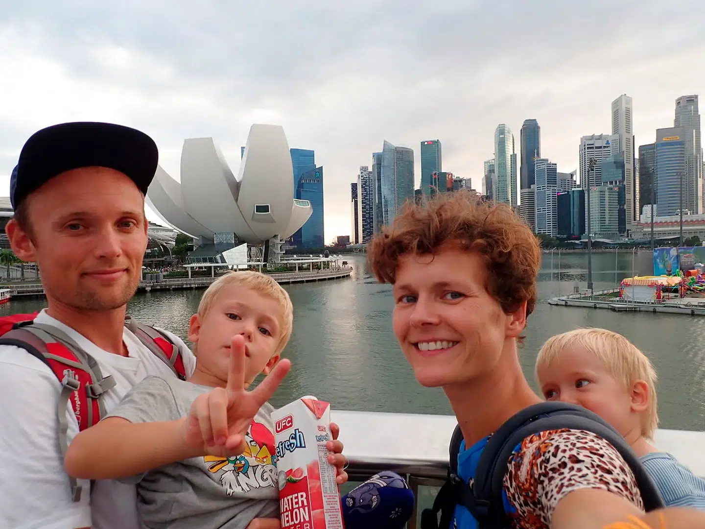 Christian Halleløv, Henriette Friis, Svend og Harly på en familie-selfie i Singapore, I baggrunden ses Singapores skyline og Singapore Art Museum.