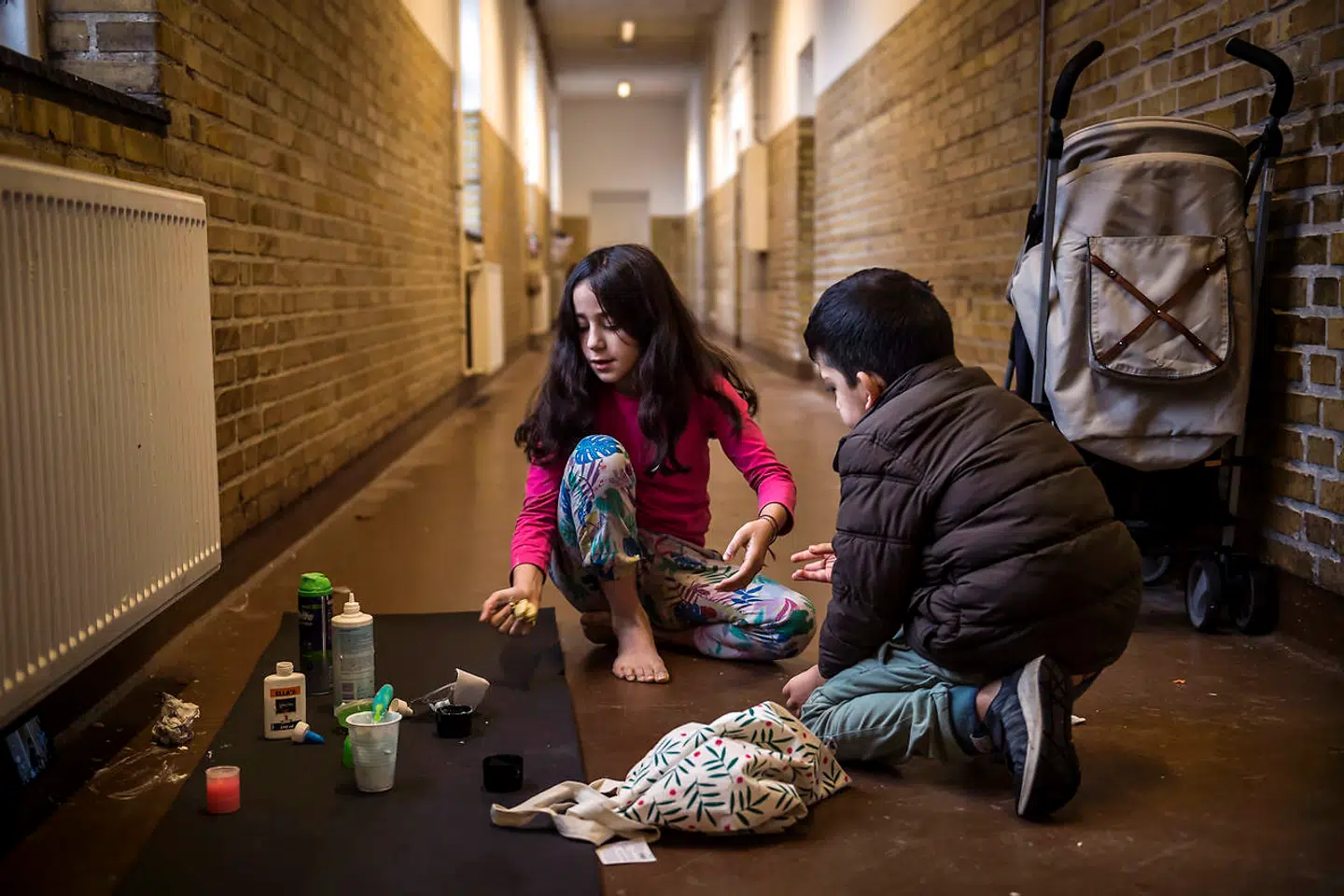 Karina på ti år leger med slim på gangen sammen med sin otteårige lillebror Elia.