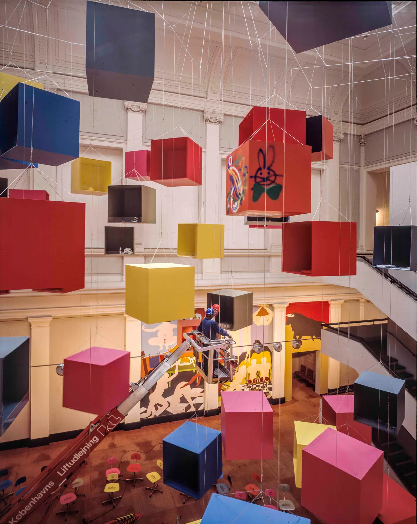 Udsnit af Eric Andersen magnum opus, »Opus 90«, skabt til Statens Museum for Kunst og vist i 1990 – uden at årstal og værknummer nu har noget at gøre med hinanden. Det er et historisk enestående billede, fordi man faktisk kan se det maleri, Lise Malinovsky skabte til lejligheden – som umiddelbart efter blev tildækket og nu indgår i Kunstmuseets samling under titlen »Det skjulte maleri«.