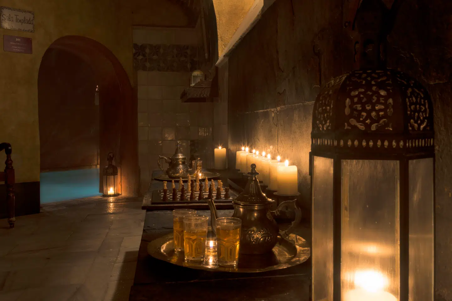 Tæt på det centrale Puerta del Sol i en okkerrød bygning med en lille undseelig indgang bevæger I jer ned ad en trappe til en hule med hvælvede baderum og flakkende stearinlys i hjørnerne.