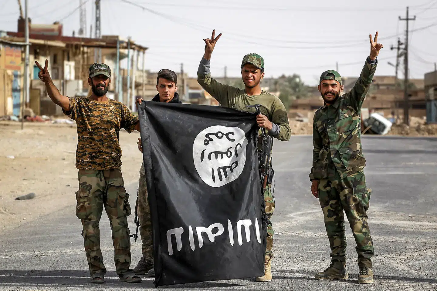Irakiske medlemmer af Hashed al-Shaabi (Popular Mobilisation Units) vender et IS-flag på hovedet i Al-Qaim 3. november 2017.