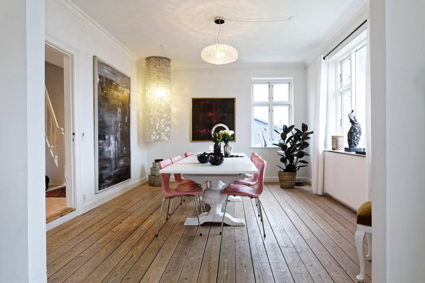 Den gamle spisestue er indrettet med pink 7er-stole, som er købt på auktion.