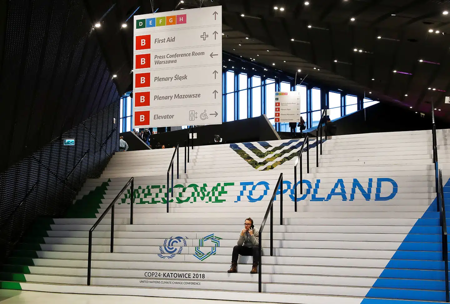 Én blandt de næsten 33.000 deltagere på COP24 tager sig et utvivlsomt velfortjent hvil på trappen til klimaforhandlingerne.