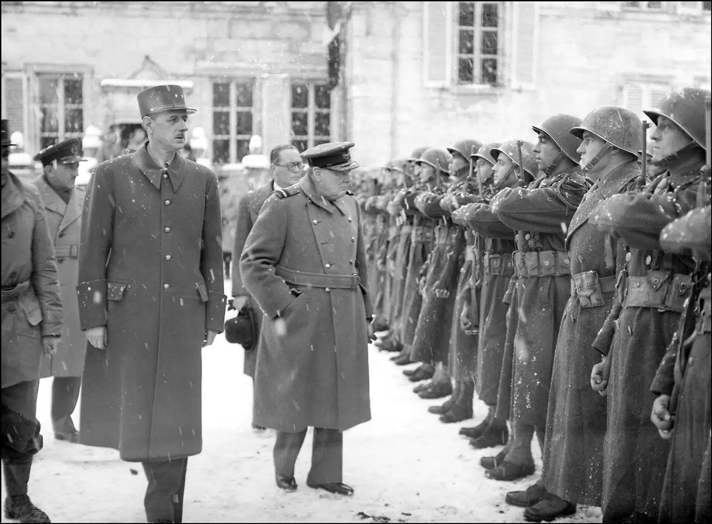 Charles de Gaulle og Winston Churchill hilser på de franske tropper  ved fronten i Alsace i november 1944. Vil man læse om de to statsmænd og ikke mindst om deres virke i Anden Verdenskrig, kan man med fordel kaste sig over to nye britiske biografier.
