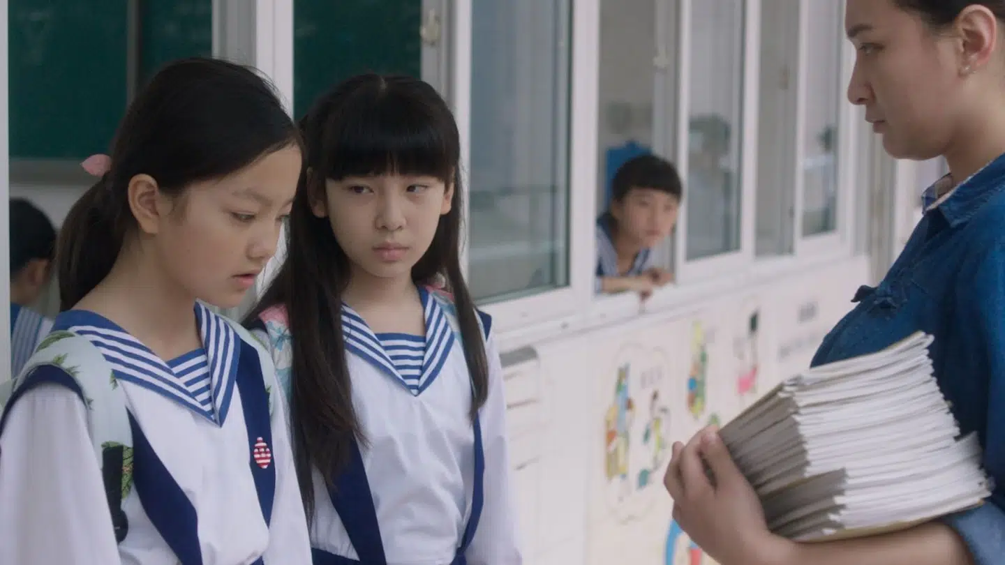 Wen og Xin bliver overfaldet - og hele systemet reagerer med fornægtelse og anklager. Her er det skolelæreren, der beder pigerne skriver 100 ords selvkritisk stil, da de kommer for sent