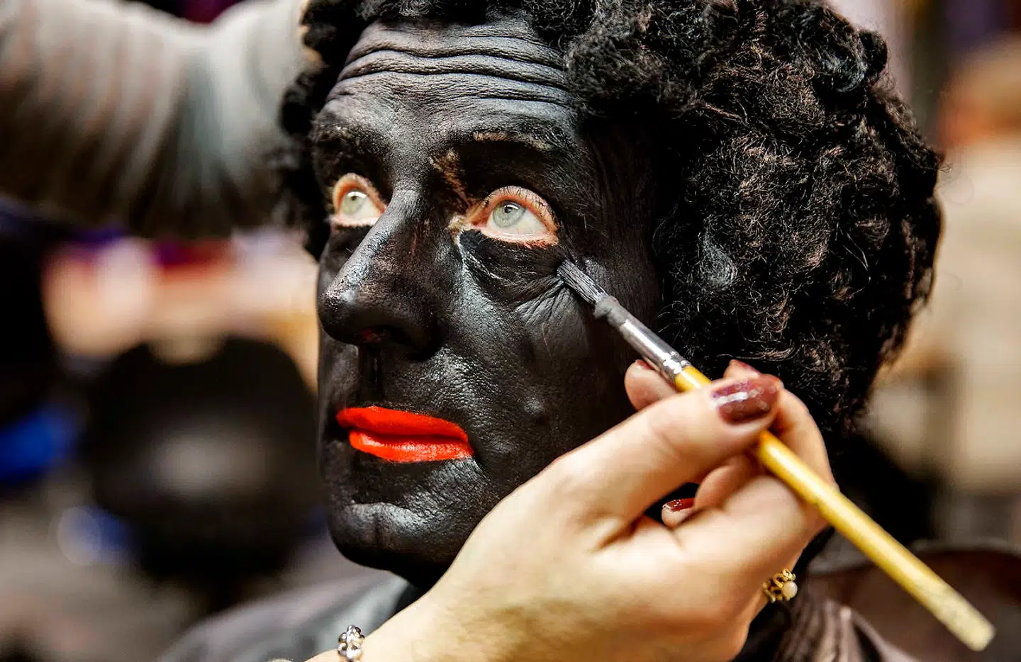 En make-up artist maler en mand sort i ansigtet. Han skal senere optræde som Sankt Nicolaus' hjælper Zwarte Piet. Arkivfoto: Jerry LampenEPA/Ritzau Scanpix