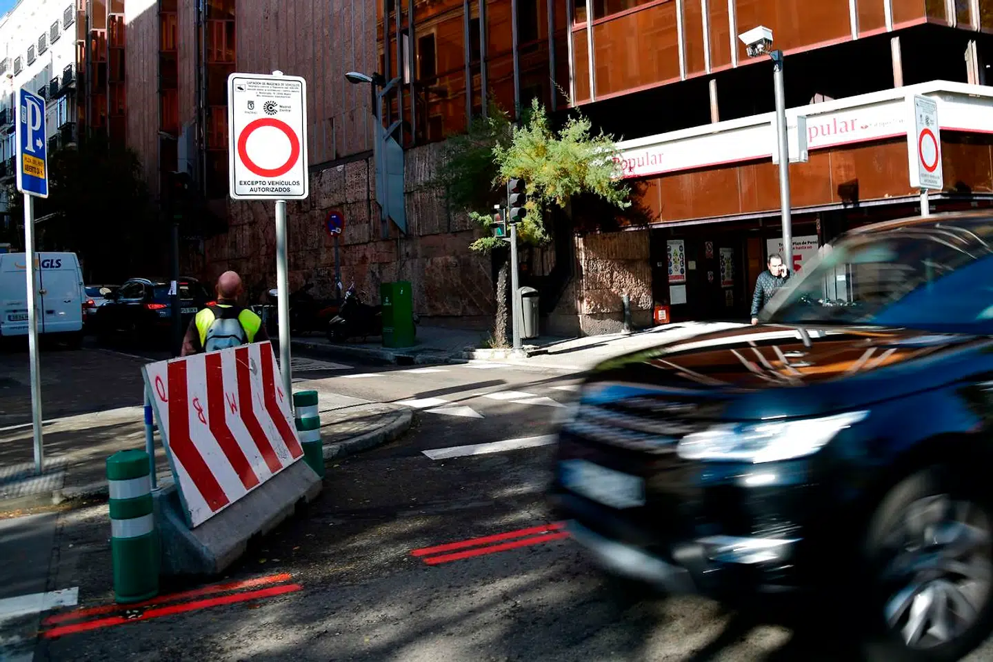 En SUV kører forbi et skilt med teksten »ingen adgang undtagen biler med særlig tilladelse« på en gade i Madrid centrum fredag, hvor de nye trafikrestriktioner trådte i kraft.