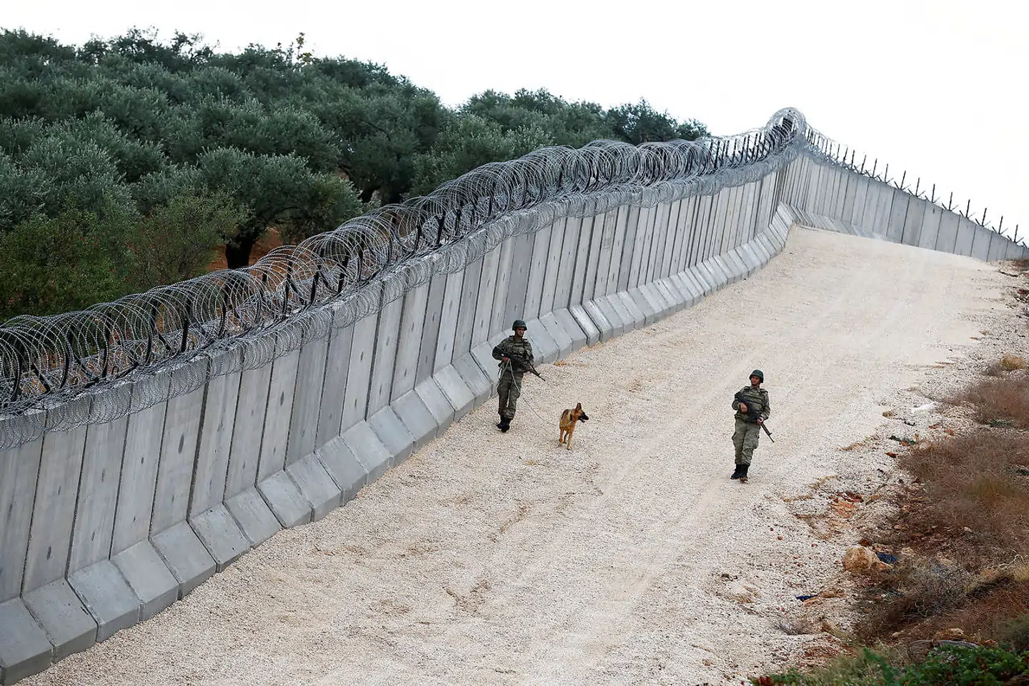 Tyrkiet har opført en 911 km lang mur langs grænsen til Syrien, og EU har bidraget med overvågningsudstyr. Her går en patrulje langs mure tæt på Besaslan i Tyrkiet. Foto: Ritzau / Scanpix / Reuters / Umit Bektas
