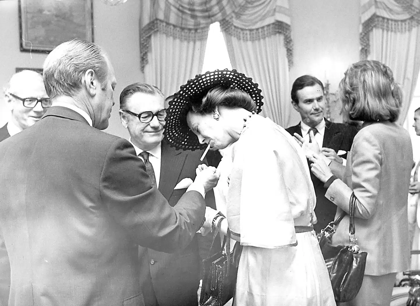 Dronning Margrethe II ryger en cigaret under et besøg hos USAs præsident Gerald Ford, der giver hende ild. Foto: Allan Moe