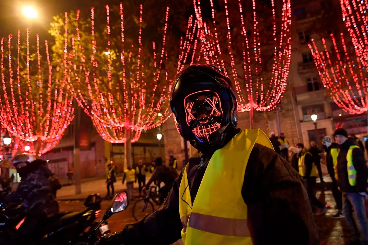 En maskeret »gul vest« på sin scooter nær Triumfbuen ved Champs-Élysées i Paris lørdag aften. Byens politikorps affyrede tåregas og vandkanoner under demonstrationen.