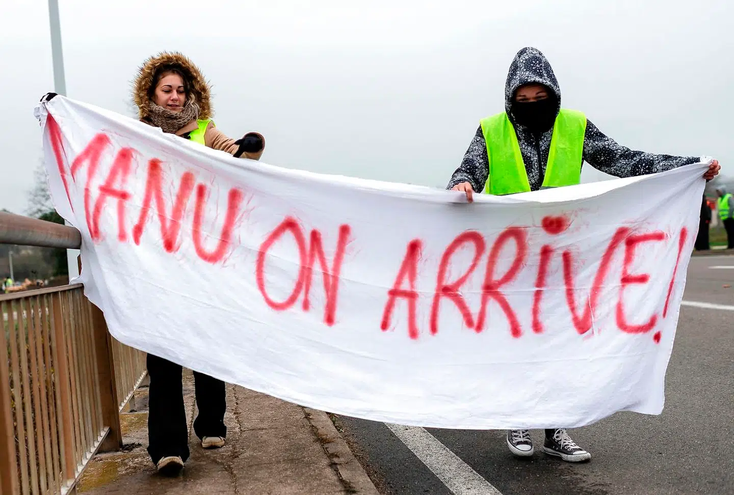 »Manu, vi er på vej« står der med henvisning til præsident Emmanuel Macron og lørdagens demonstration i Paris på banneret, som to personer fra De Gule Veste bærer nær Montceau-les-Mines i det centrale Frankrig. Foto: Romain Lafabregue/AFP/Ritzau Scanpix