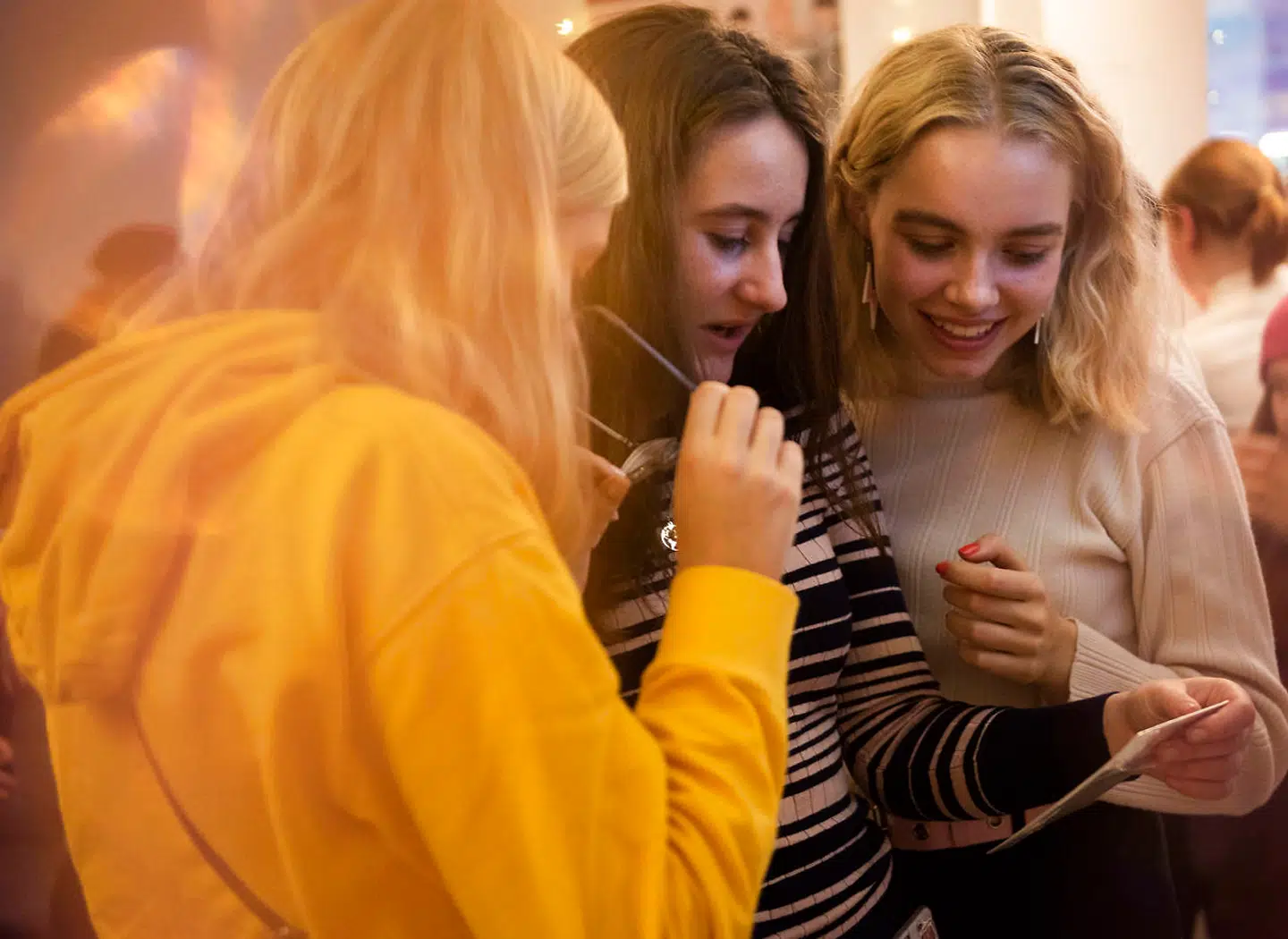 Veninderne Olivia Christiansen, Emmy Christiansen og Freja Pedersen kigger på samlekort med K-pop-sangere.