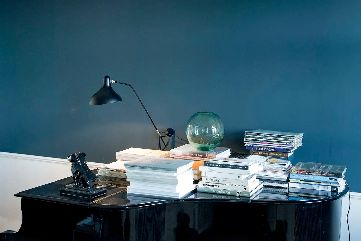 »Den blå farve på væggen ved flygelet er en Farrow & Ball-farve og hedder Hague Blue. Det er kun de dér dedikerede steder som Tapet Caféen, der fører den maling,« fortæller Nikolaj Koppel, der også afslører, at det er hustruen, Sille Kroyer Koppel, der står for farveholdningen derhjemme.