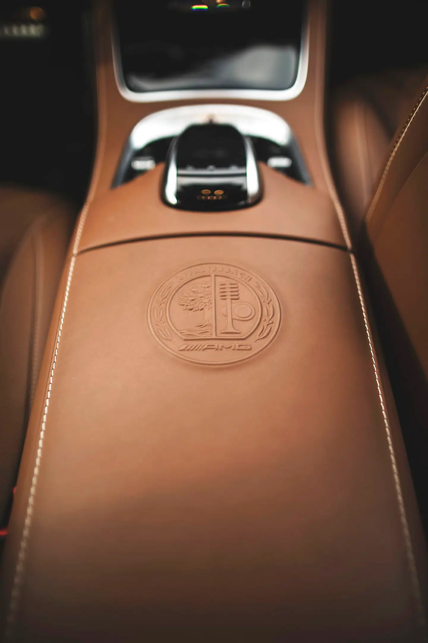 AMG's våbenskjold pryder midterarmlænet, og viser, at det her er en vogn fra Mercedes hårdkogte performanceafdeling. På motoren er et tilsvarende logo, og lige under har manden der har samlet netop denne motor sat sin signatur. Foto: PR