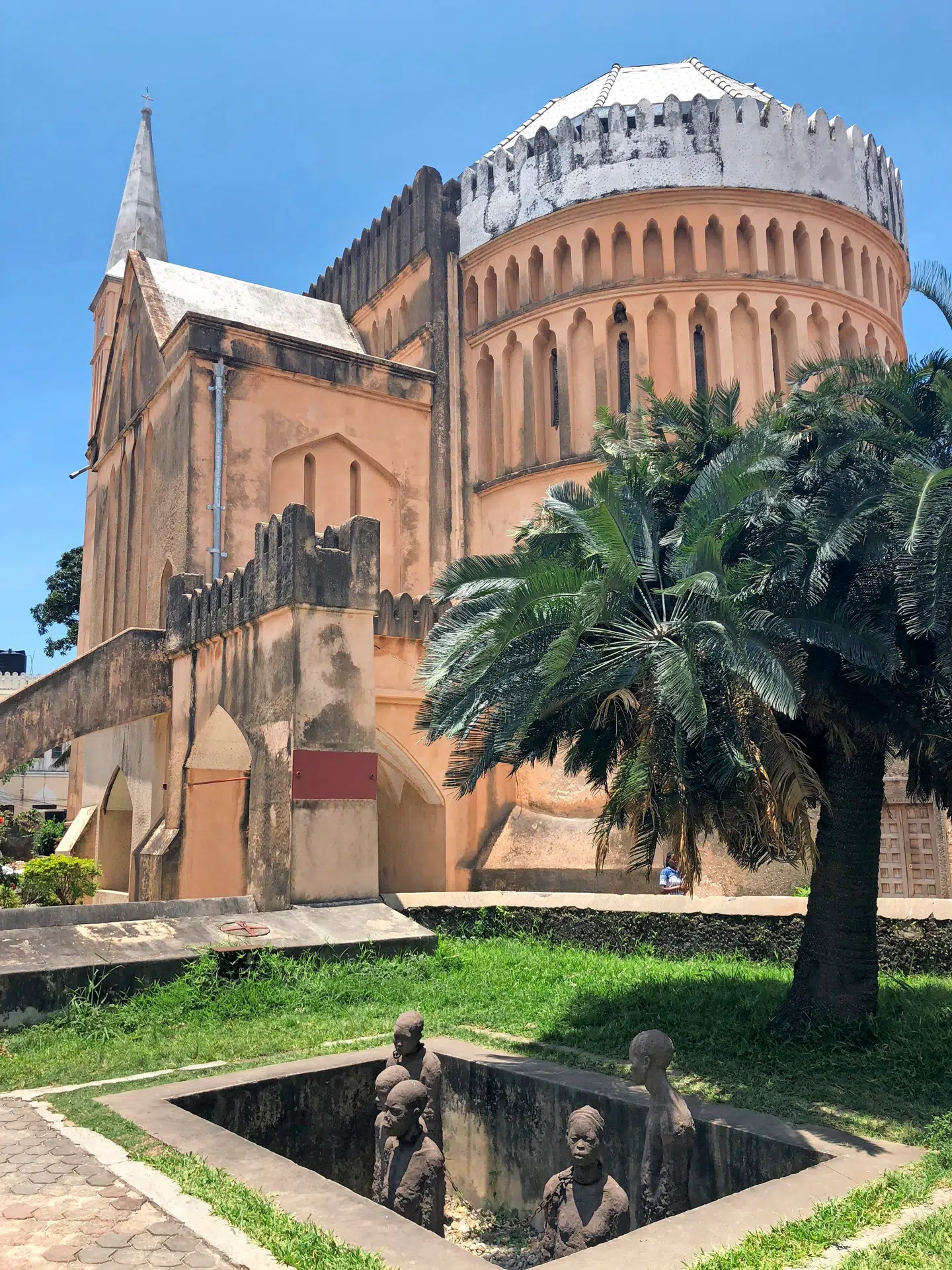 Foran kirken, der er bygget midt i det gamle slavemarked, er et monument over fortidens slaver. Lænkerne er originale.