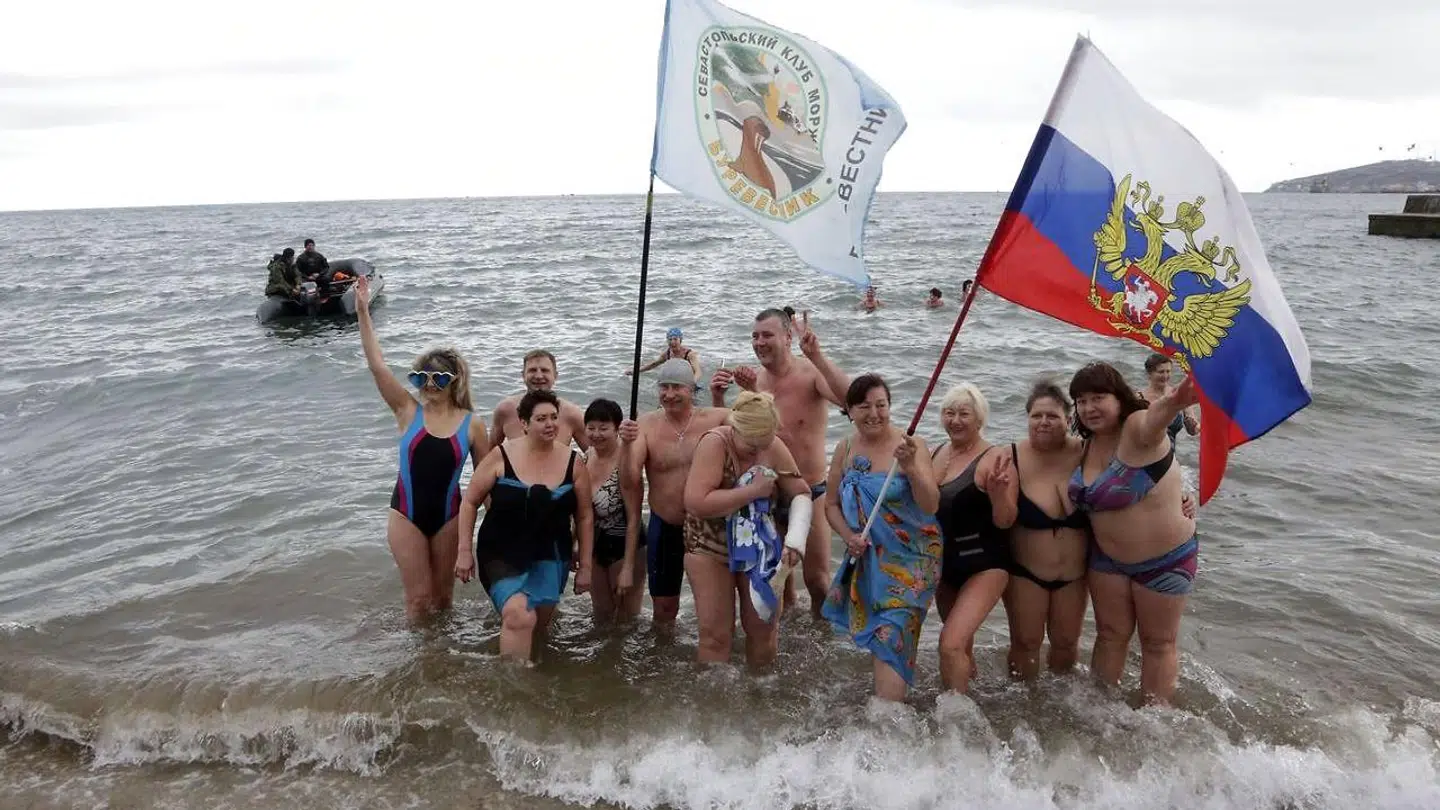 Medlemmer af Krim-halvøens vinterbadeklub poserer på stranden i 2015. Nu har den russisk-støttede regering i landet lagt en plan for, hvordan de skal få nye internationale turister til det sanktionsramte land.