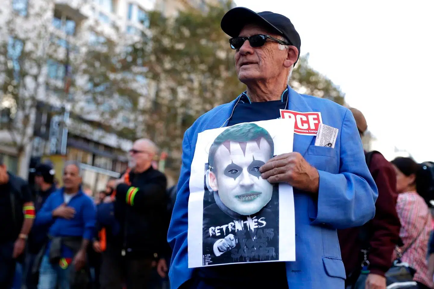 En demonstrant protesterer tirsdag i Paris mod Emmanuel Macrons politik over for Frankrigs pensionister, som præsidenten i sidste uge opfordrede til at holde op med at brokke sig.