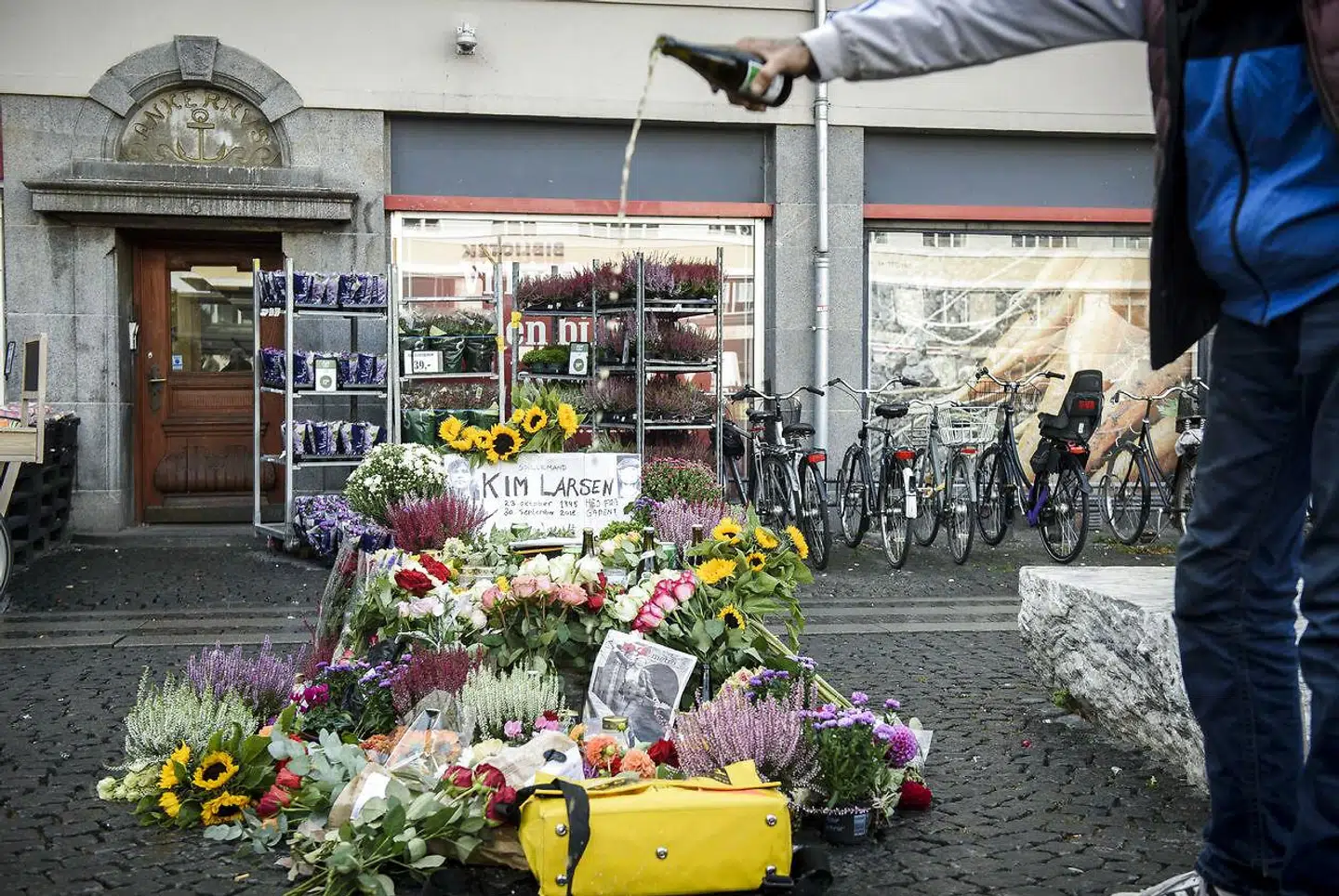 Kim Larsen er død. Christianshavns Torv. En lokal »ofrer« en øl for den afdøde sanger.