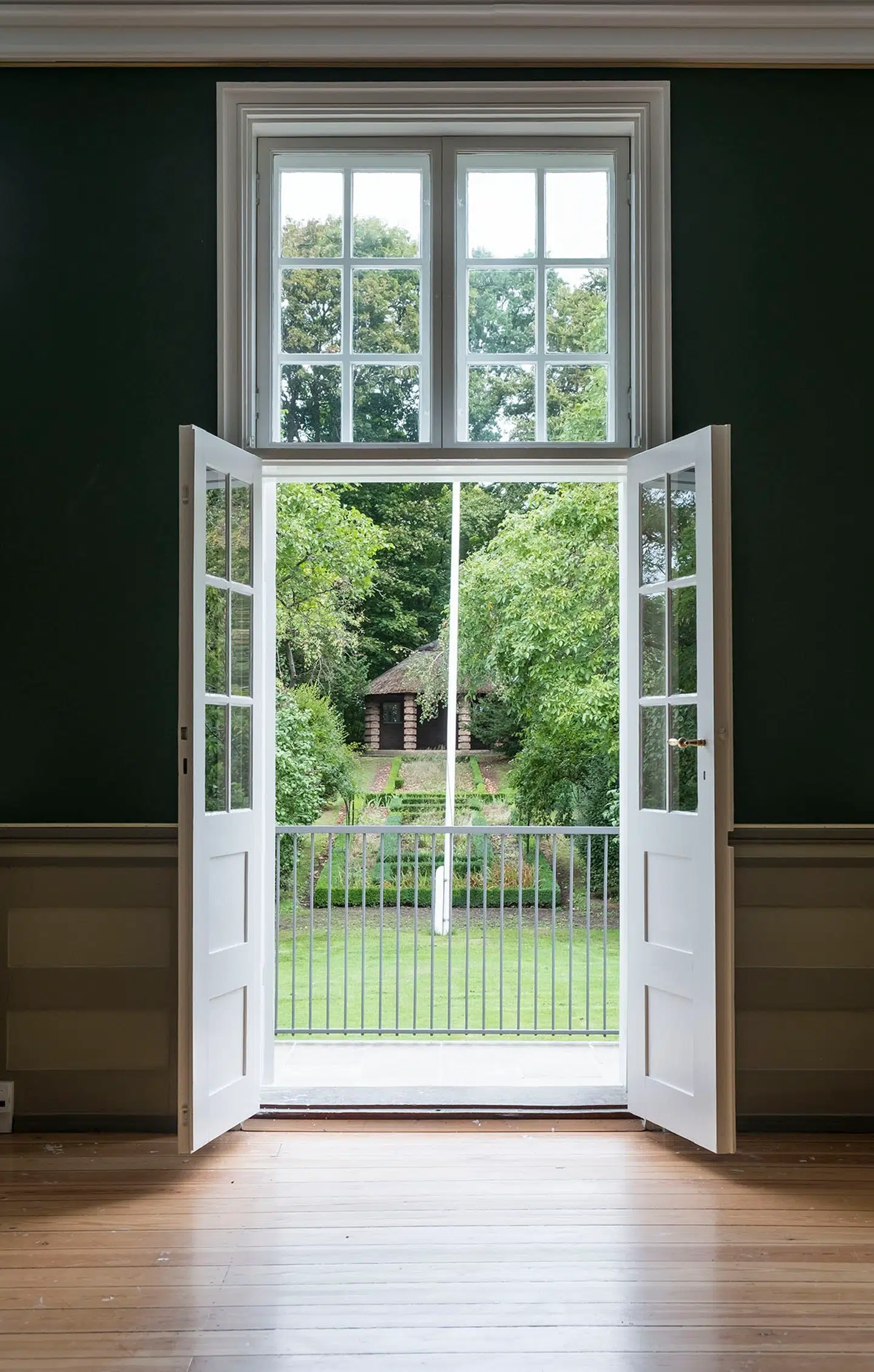 Sommerglæder! Gennem spisestuens åbentstående døre ser men ud i den parklignende have, der hører til Bakkehuset i Holbæk. I det fjerne skimtes en pavillon. Fra enden af haven var der på et tidspunkt fuldt udsyn over Holbæk fjord. Pressefoto