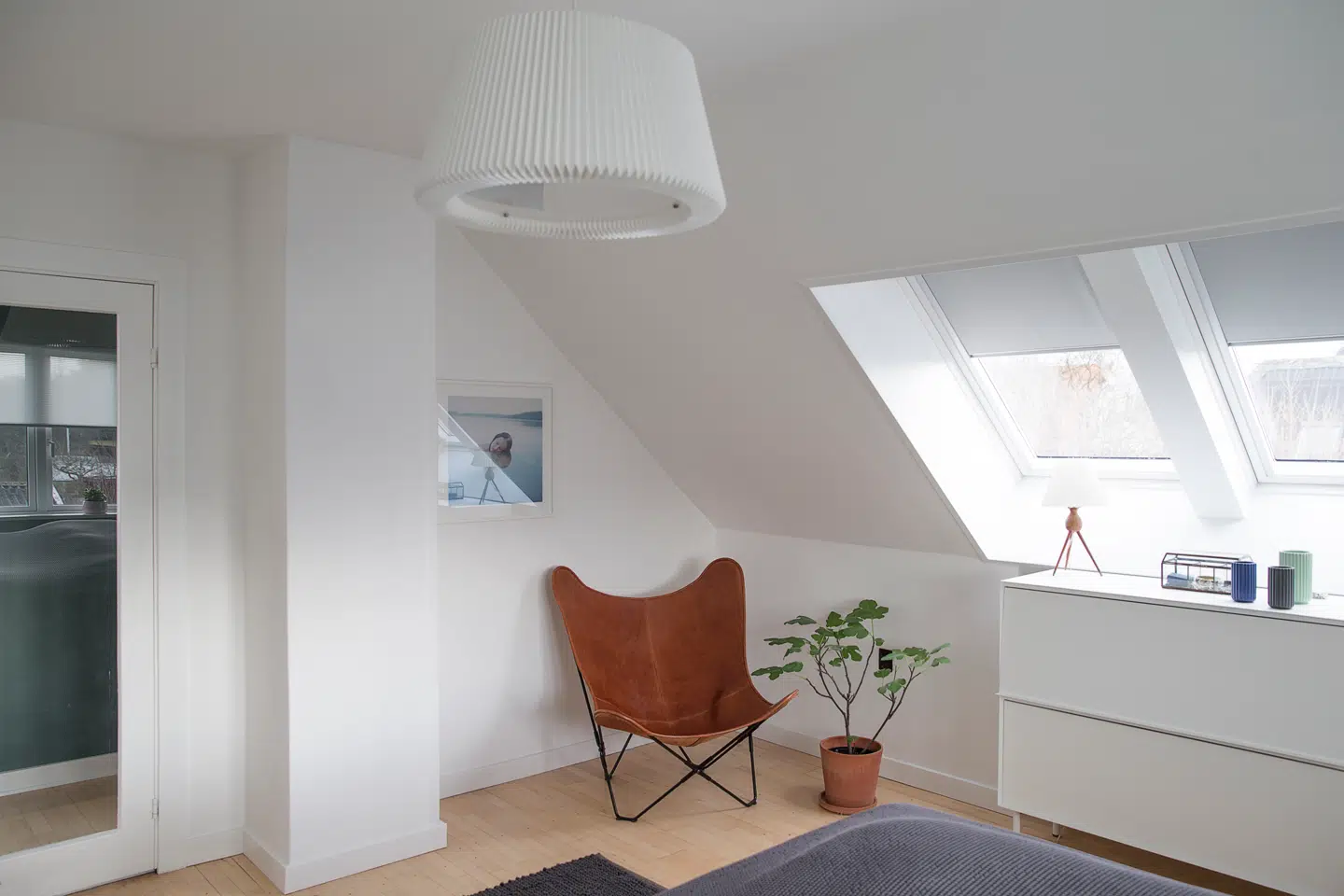 Det rummelige soveværelse har plads til både en stor dobbeltseng, kommode og en hyggelige læsekrog, hvor Nanna Brinkler har placeret en Flagermus-stol fra Casa Shop. I vinduet står en bordlampe, som parret har arvet fra Martins mormor, mens den store kommode er fra Hay. Over den svæver en let pendel fra Le Klint.