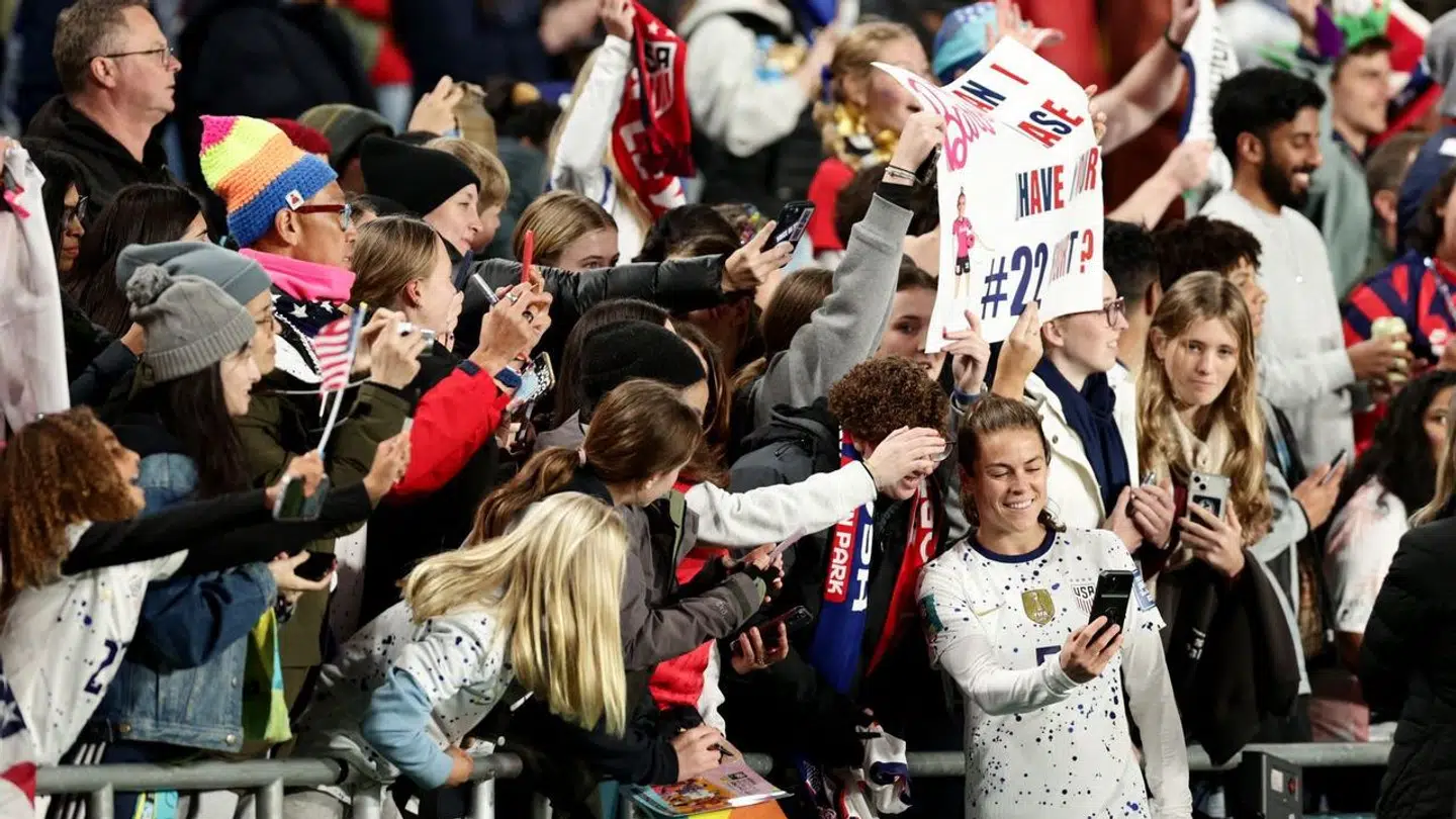 Det er blandt andre billeder som disse, der har vakt harme i USA. Her ses Kelley O'Hara, der tager billeder med fans.