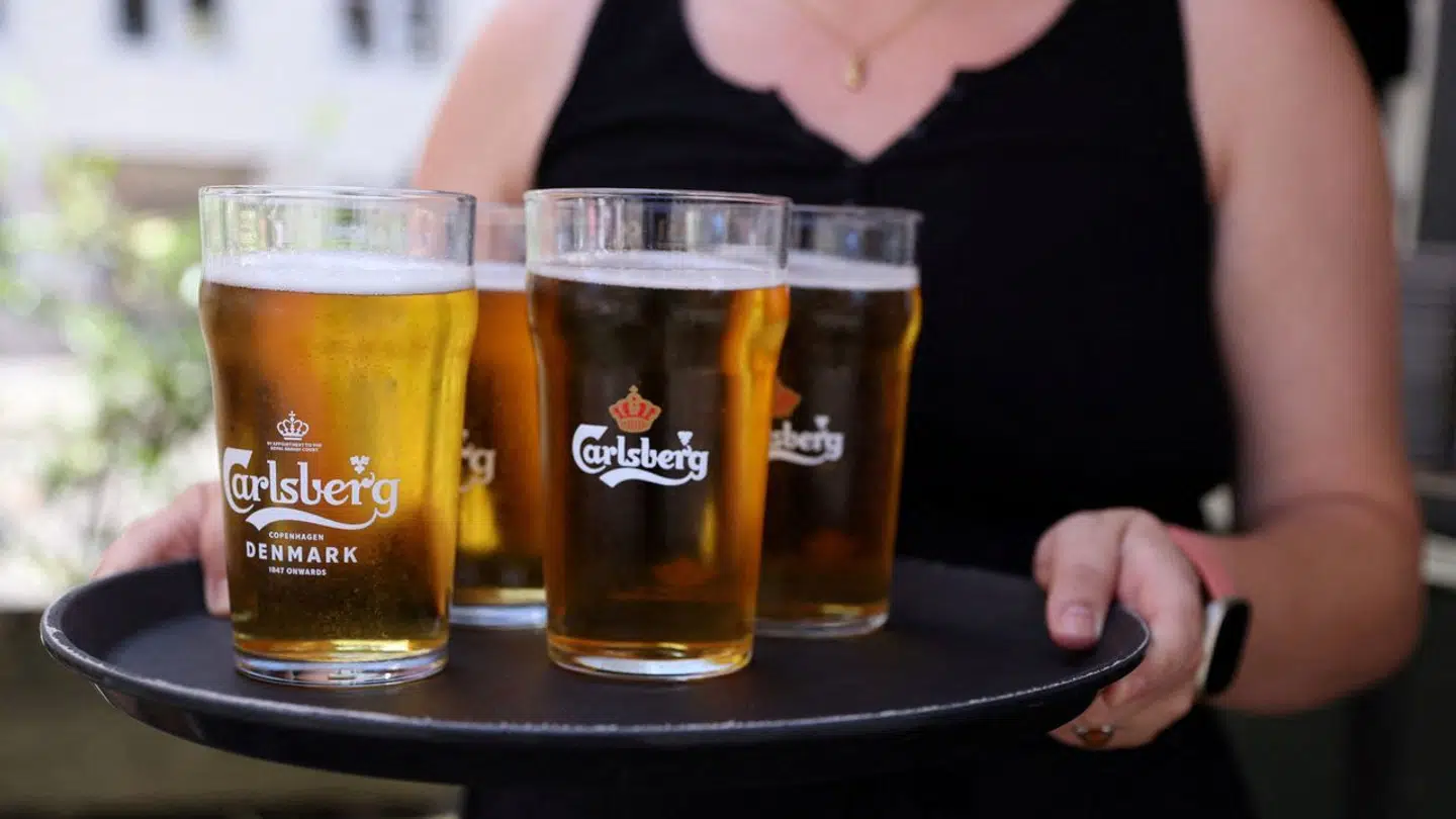 FILE PHOTO: A bar worker carries a tray of Carlsberg beer in Copenhagen, Denmark, July 30, 2022. REUTERS/Andrew Kelly/File Photo