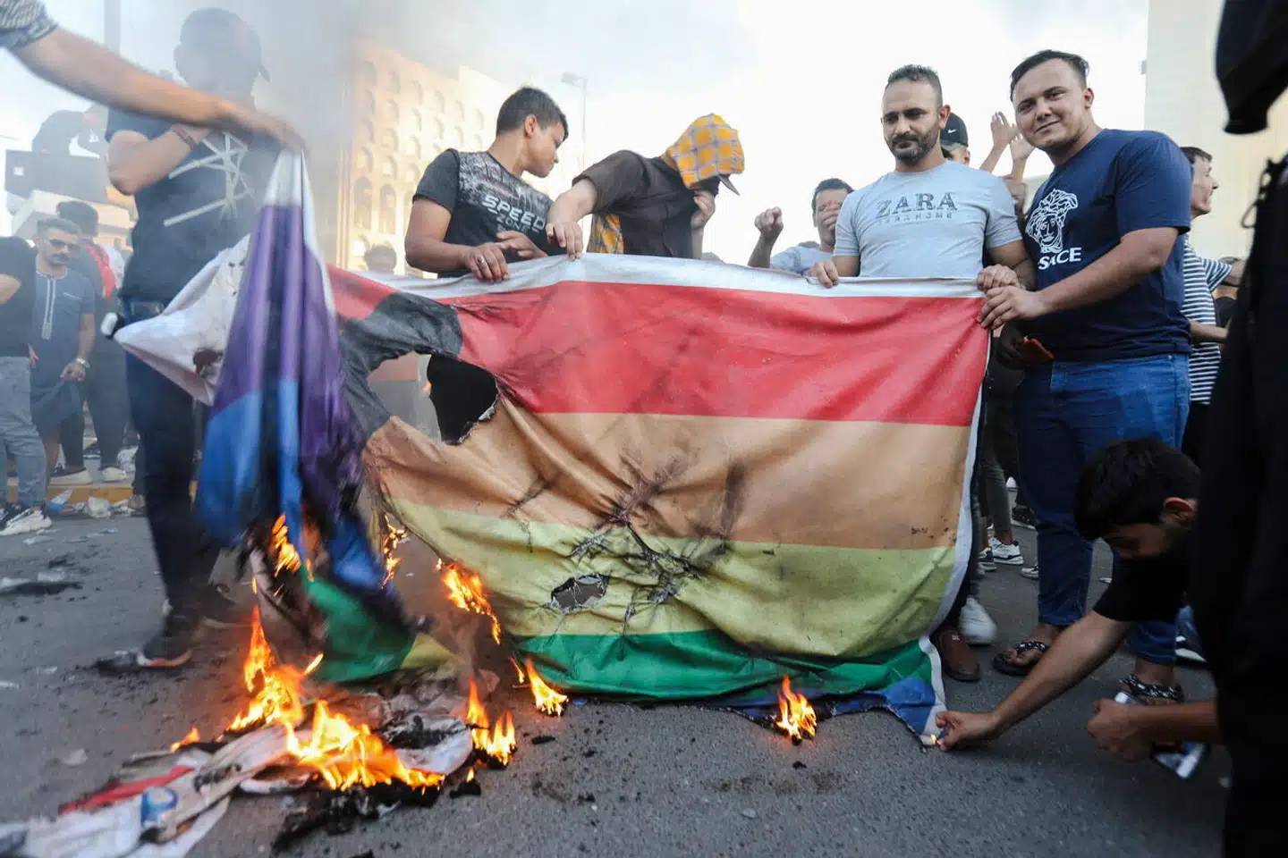 I disse dage kan man i Danmark købe alskens regnbuefarvede produkter i Netto, mens regnbueflaget samtidig bliver brændt af overalt i Mellemøsten. Der er simpelthen noget galt med prioriteterne hos de store LGBT-organisationer, mener Amalie Lyhne i denne leder. Billede af demonstranter i Bagdad i Irak, der brænder regnbueflaget.