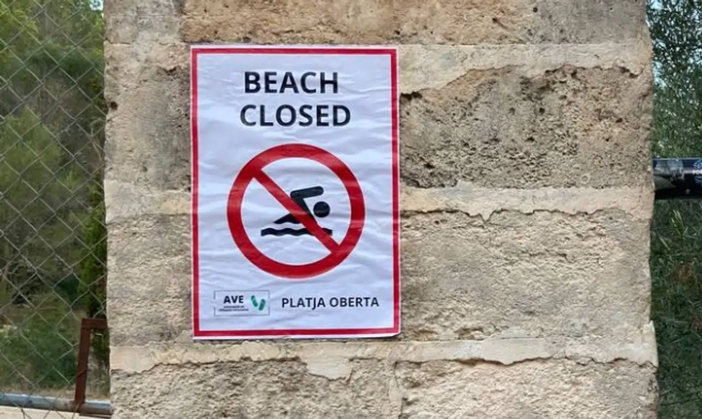 Turister advares i tydelige vendinger om, at det ikke er en god idé at opholde sig på stranden. Nedenunder står der dog noget helt andet på catalansk.