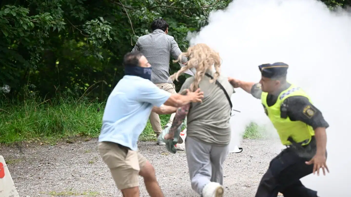 STOCKHOLM 20230818 En motdemonstant sprang fram och försökte med en brandsläckare att släcka elden på den koran som Salwan Momika antänt vid en demonstartion utanför Irans ambassad på Lidingö. Foto Fredrik Sandberg / TT kod 10080. (Foto: 10080 Fredrik Sandberg/TT/Ritzau Scanpix)