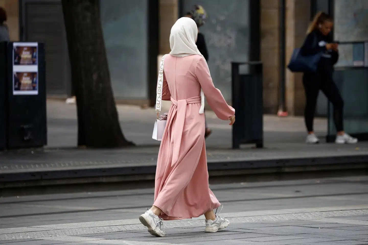 En kvinde bærer abaya og hovedtørklæde på gaden i den franske by Nantes. Fra mandag må skole- og gymnasieelever ikke længere bære abaya, når de er i skole. Stephane Mahe/Reuters