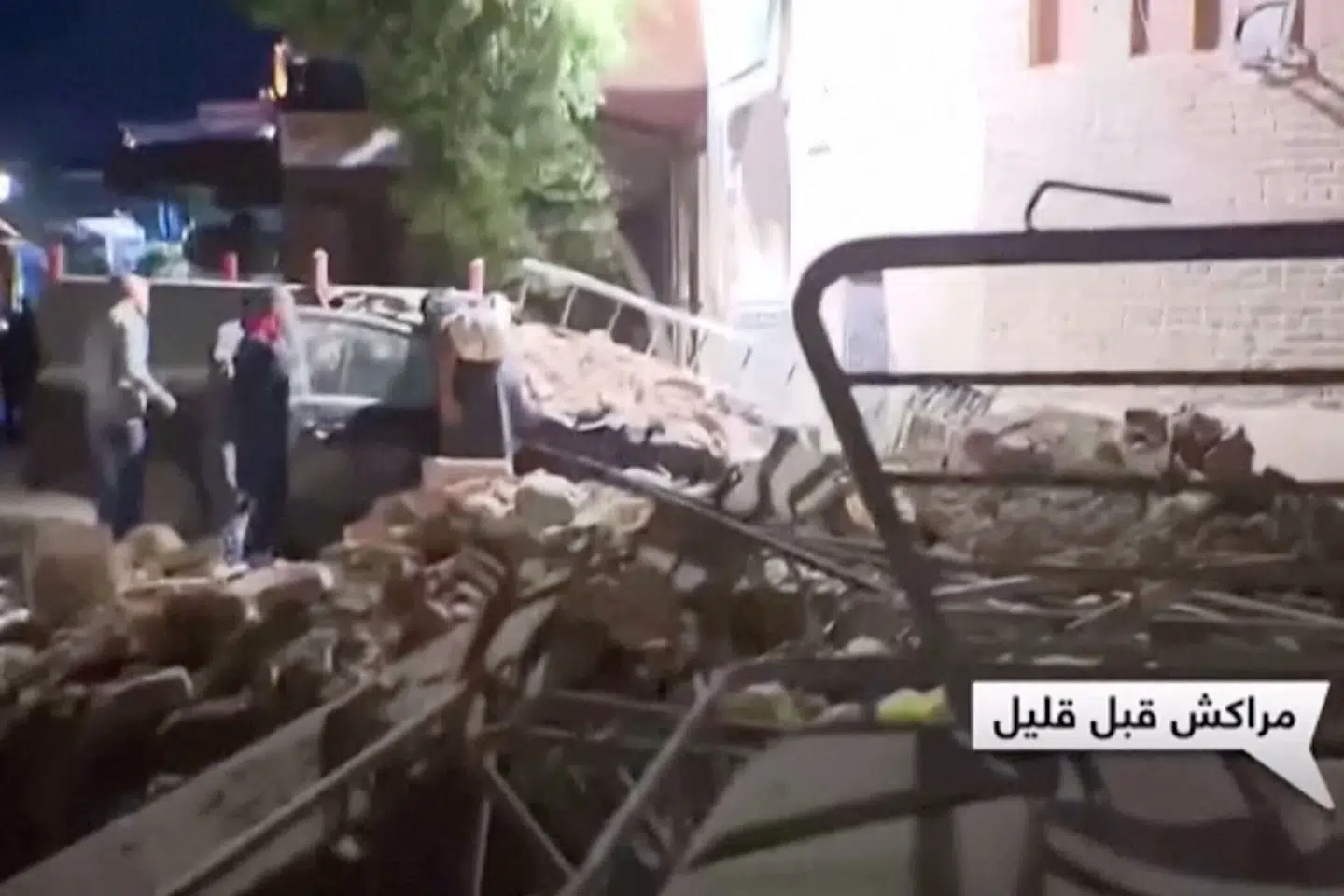 Folk ser til, hvor bygninger er styrtet sammen i den marokkanske storby Marrakesh, som ligger tæt på der, hvor jordskælvet fredag aften indtraf. Al Oula Tv/Reuters